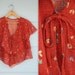 1970s.floral tired. fredericks of hollywood. glitter ruffle blouse. s-m