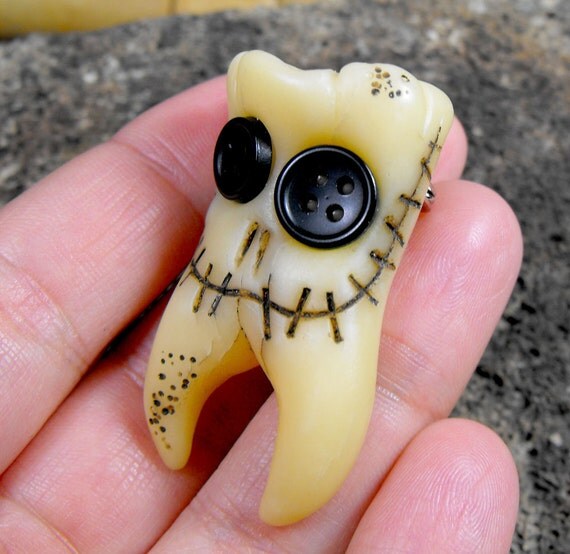 Smiling molar monster. Human teeth brooch with two roots and
