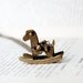 The rocking horse necklace - necklace with a rockinghorse and a bow. Antiqued bronze.