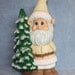 Handpainted Ceramic William Gnome in Winter White and holding on to a Pine Tree