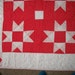 Red and white quilt with matching throw-pillow covers, beautifully hand quilted.