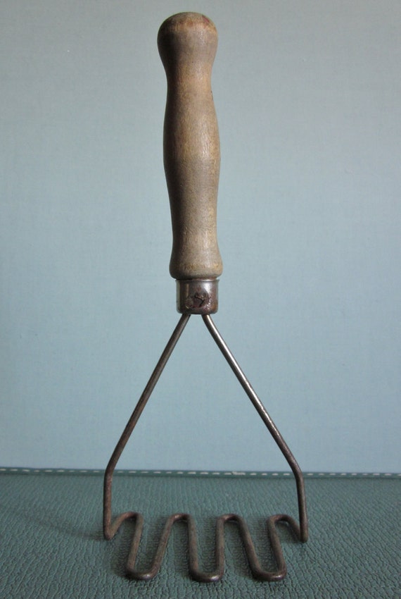 Vintage potato masher metal with old wooden handle