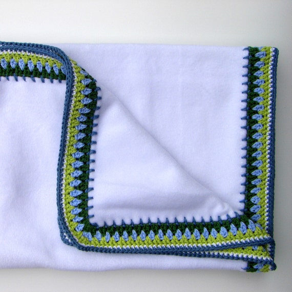 Baby blanket in white fleece with green and blue crochet edge