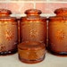 1970s Tiara sandwich glass 4 piece canister and candy dish set. Brown amber sunflower design. Indiana glassware