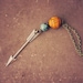 mercedes. a beaded silver arrow necklace in orange and teal.