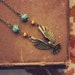 skylar. a beaded brass bird in flight necklace.