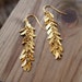 Long gold dangling earrings,Delicate, dangling Goddess-earrings with cascading leaves in gold , gold dangle earrings