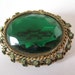 big green brooch, 1960's brooch, mad man accessories, big oval shaped green rhinestone brooch framed in a beautiful filigree inlayed frame