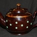 Little vintage brown teapot with green polka dots