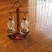 Vintage and antique salt and pepper shakers on a stand.