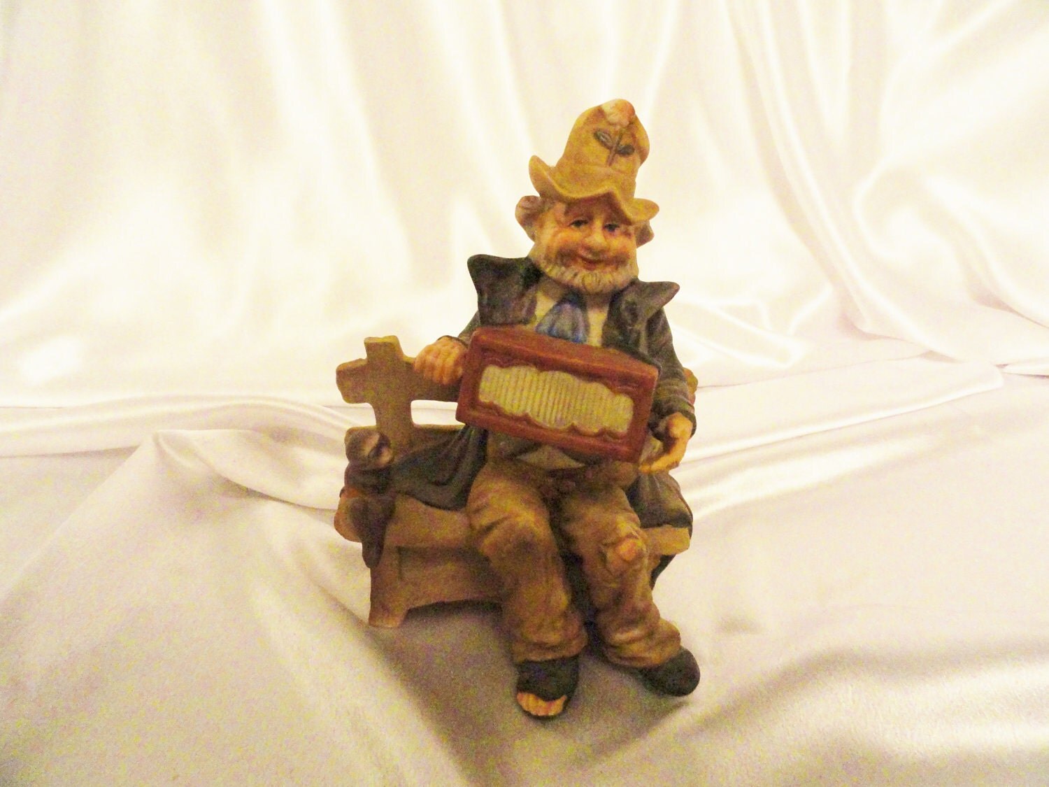 Vintage hobo figurine plays music box while his monkey looks