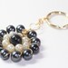 Wire beaded keychain in metallic black and off white, gold toned wire wrapped