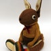 Woollen Rabbit - Handmade plush sculpture - brown woollen body with flesh coloured felt ears - wearing mustard woolly pullover.