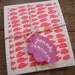 A pair of hand printed "Hundreds & Thousands" dishcloths in orange and pink - biodegradable