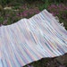 Hand woven, rag rug, in rainbow colors, with hem stitching and fringe