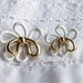 28 Vintage White and Gold Tone Plastic Shank Buttons Shaped like a White Flower with a Gold Tone Bow Item 0213
