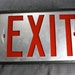 VIntage Lighted Exit Sign with Red Letters on Silver Background In Black Box