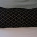 Black and Gold decorative lumbar pillow cover with illuminated lattice pattern and self piping
