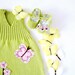 A knitted baby dress with flowers and butterflies in green-lime. 100% cotton. Newborn.
