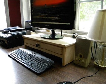 Computer monitor stand with drawer for extra storage and hidden hole in drawer back for cell phone chargers