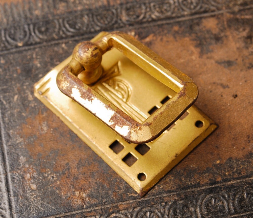 Antique brass escutcheon plate with drawer pull handle.