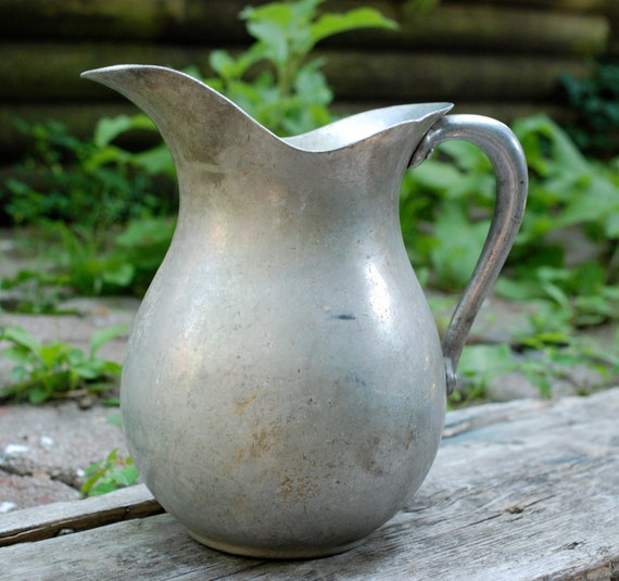 Vintage metal pitcher with unique curved lip