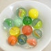 12 vintage orange, green, turquoise, yellow swirl colored marbles