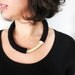 black minimal bold geometric tube necklace with an ivory curve
