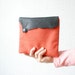 Clutch bag in orange vintage fabric with leather flap in black