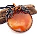 Copper pendant with lace Agate in halloween orange and black, circle round as a pumpkin, with snails swirls curls