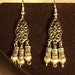 Little sea shell beads and Tibetan silver tube beads on antiqued silver findings hang on sterling silver ear wires.