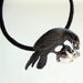 Raven with Black Onyx Eyes with a Sapphire in its beak while clutching a Skull