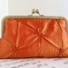 Pinched taffeta tangerine orange clutch bag in frame