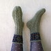 Hand knitted cabled wool socks with ornament.