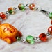 Orange Buddha Face with green faceted glass beads Om Jewelry Bracelet