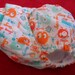 SassyCloth one size pocket diaper with guppy ooga booga PUL print. Ready to ship.