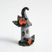 Miniature haunted house fairy cake topper for Halloween made from polymer clay in black and orange