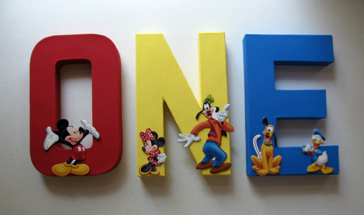 mickey mouse one letters in red yellow and blue with by