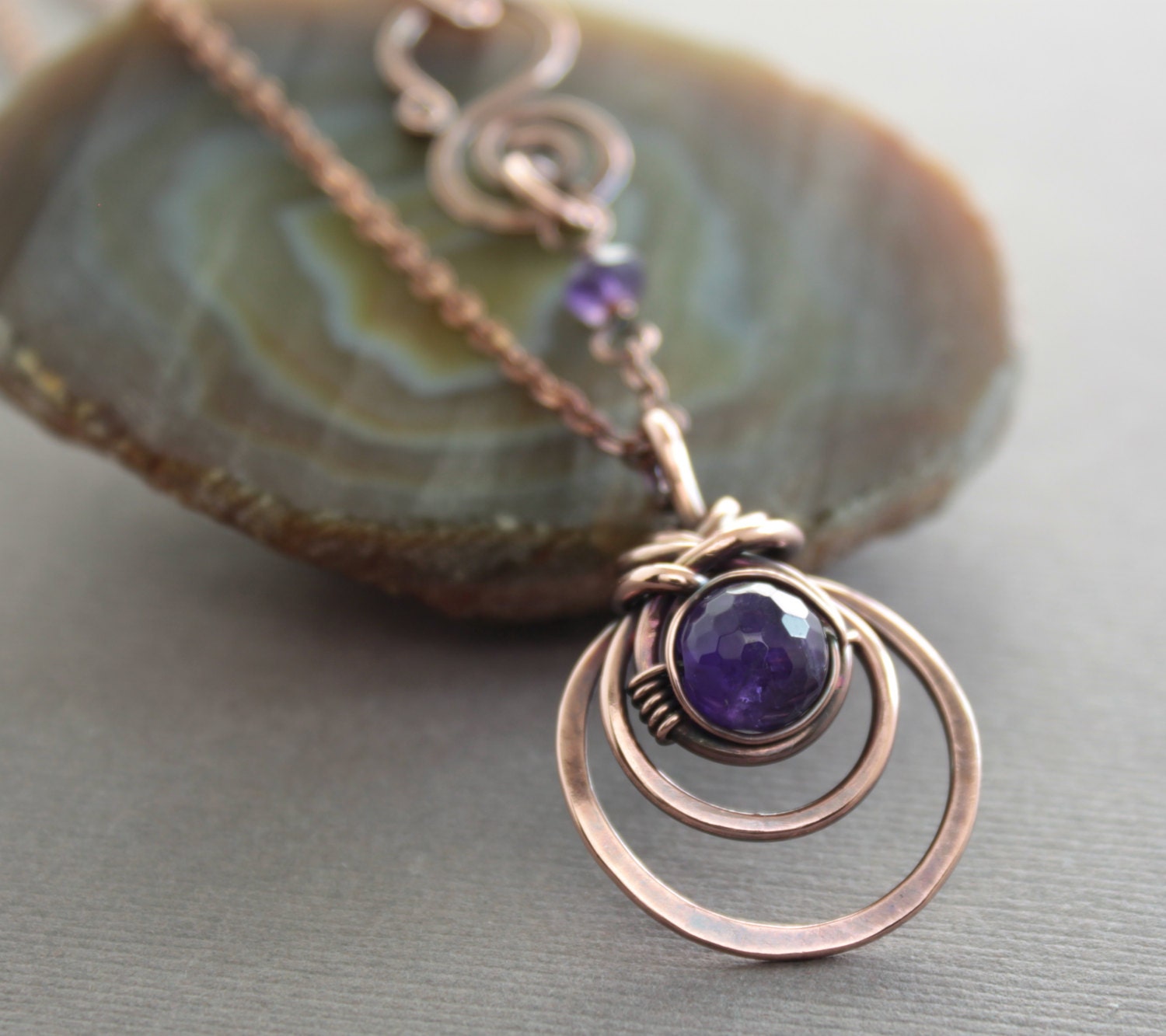 Copper necklace with woven round pendant and amethyst stone on