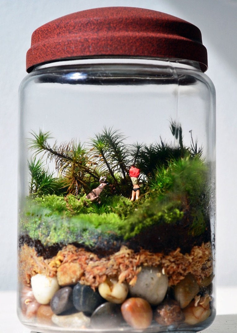 Moss terrarium in glass jar with reindeer and little figure