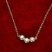 old gold necklace with three white stones placed together jewelryhad