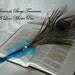 Peacock Feather Pen wrapped with greenish blue metallic ribbon accent yellow jewel and bow Black Ink writes smoothly on paper with no drag