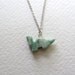 Tiny green stone dinosaur charm necklace on sterling silver plated chain