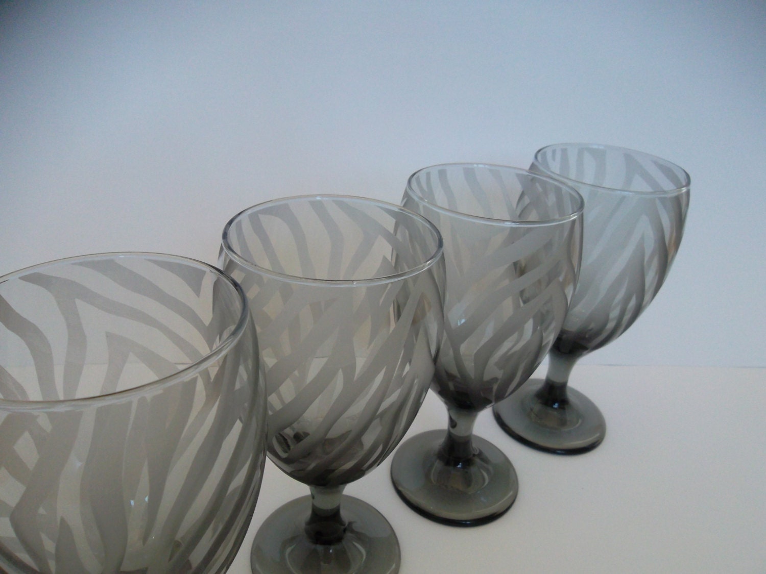 Black drinking glasses etched with zebra print. Set of 4.