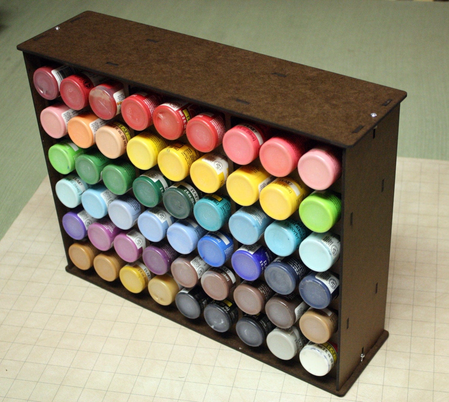 Paint rack holds 54 craft paint bottles.
