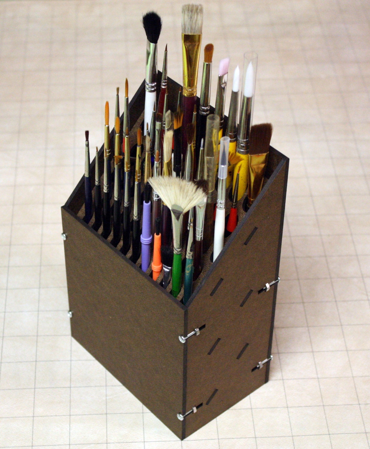 Paint brush rack holds 17 larger brushes and 32 smaller