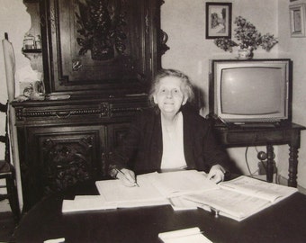 French 1960's B/W Photograph - Old Woman Sat at a Table Writing