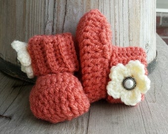 Crochet baby girl boots, in salmon with cream flower and pearl button center. size 0 to 3 mo.