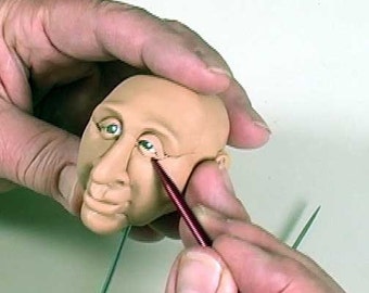 A PFDVD - Sculpt using Puzzle-Face Push Molds by Maureen Carlson. It's a great tool for polymer clay users.