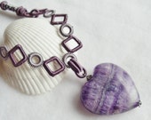 Heart shaped amethyst stone necklace, on purple fabric necklace